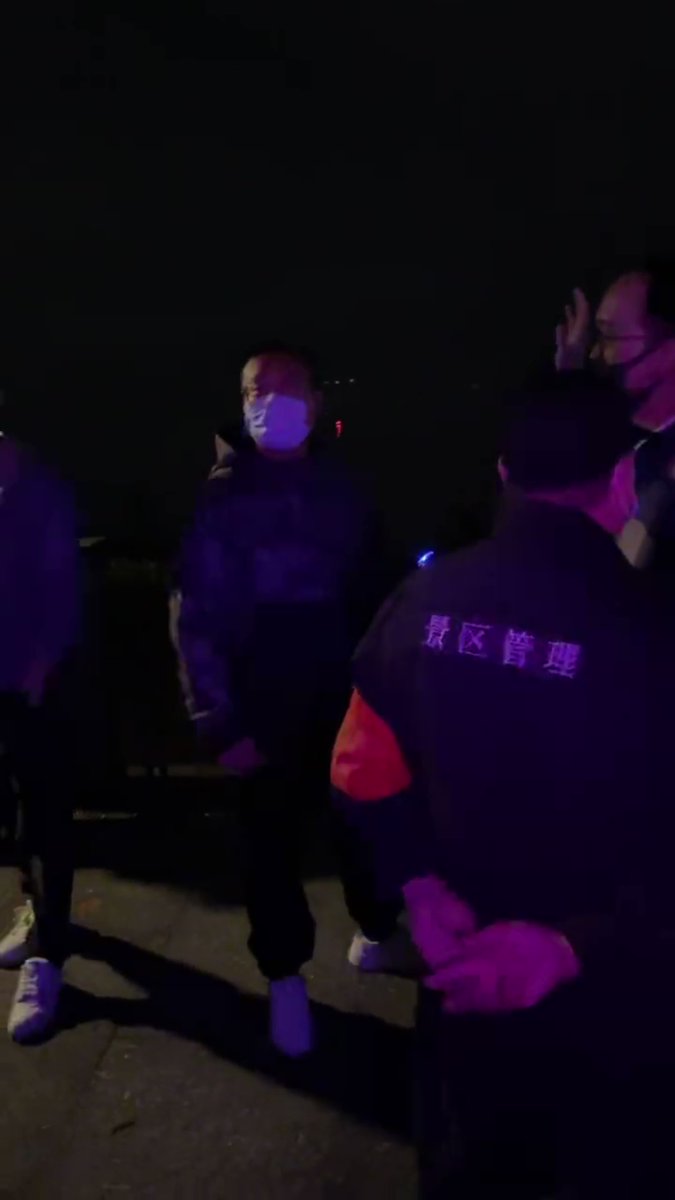 Hangzhou. People trying to prevent the police from taking a man holding flowers. One asked on what ground is the man being taken into custody. A police murmured something about foreign hostile forces in reply